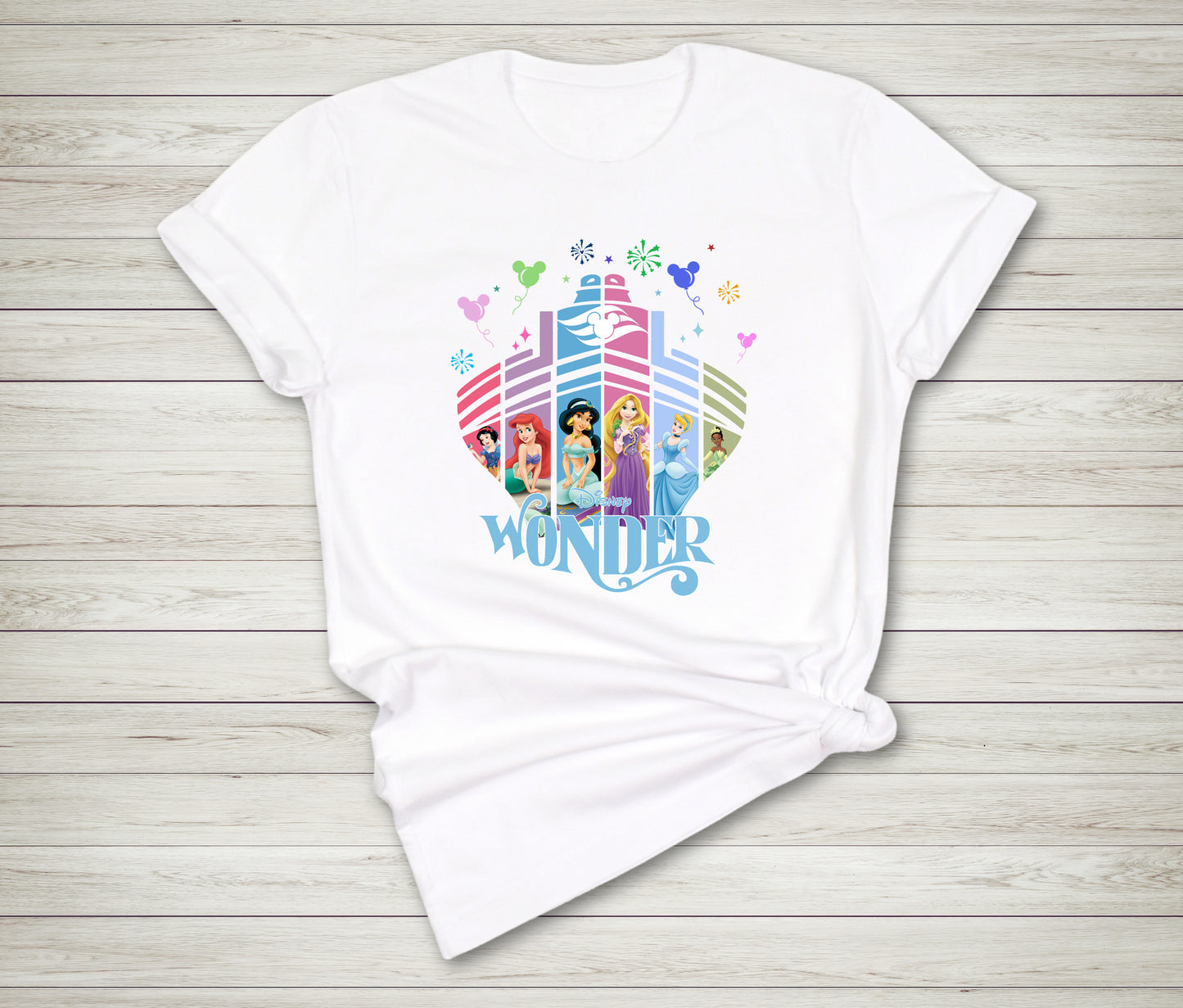 White t-shirt with colorful Disney princess design on a wooden surface