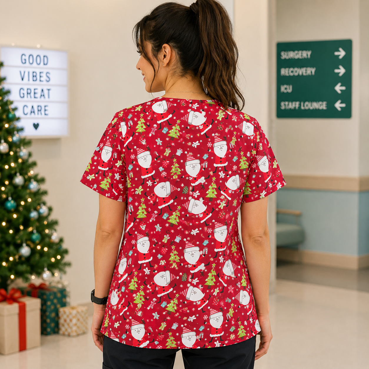 Person wearing a red Christmas-themed scrub top in a hospital setting with a decorated Christmas tree in the background.