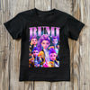 Black t-shirt with colorful character design and 'RUMI' text on a wooden surface