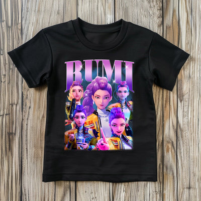 Black t-shirt with colorful character design and 'RUMI' text on a wooden surface