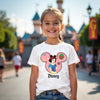 Young girl wearing a Disney-themed t-shirt with a castle in the background