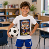 A young boy stands in a classroom holding a soccer ball, wearing a white graphic t-shirt with a 'Soccer Star of Frank' print and blue athletic shorts.