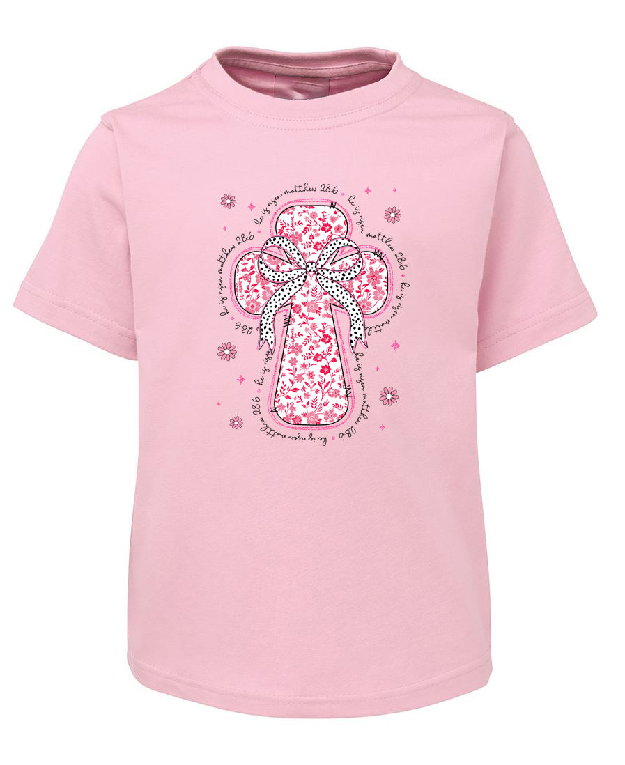 Pink t-shirt with a decorative cross design on a white background