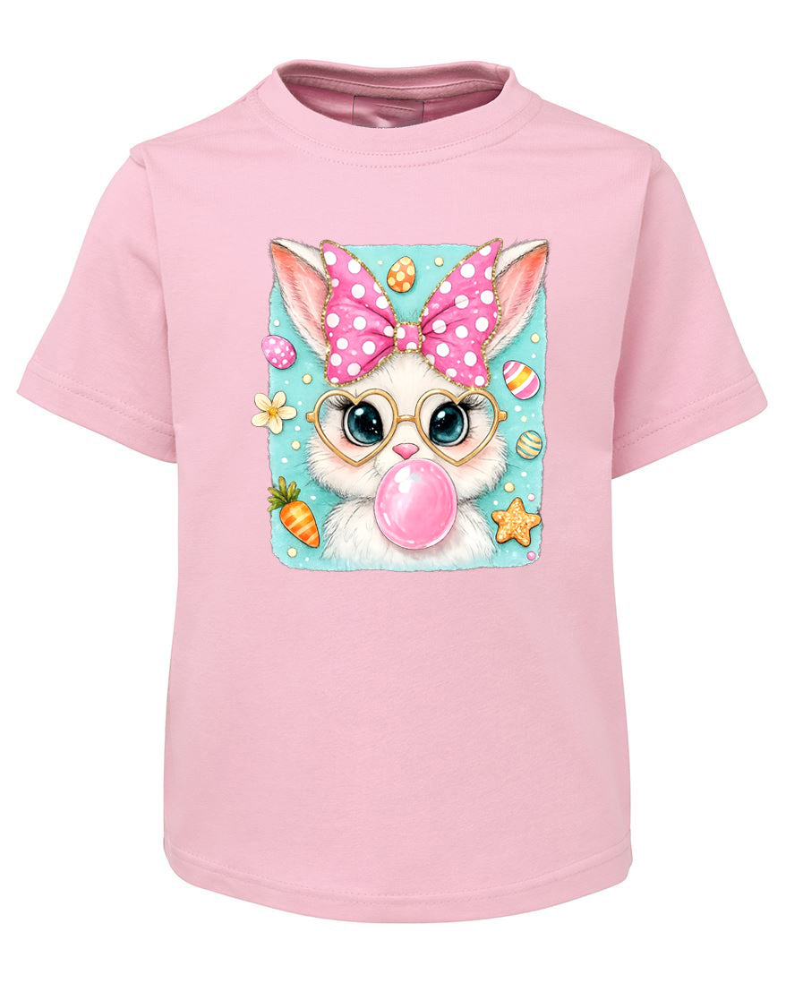 Pink t-shirt with a cartoon bunny wearing glasses and a polka dot bow, blowing a bubble gum bubble.