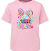 Pink t-shirt with Easter design featuring bunny ears, eggs, and text on a white background