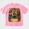 A pink short-sleeve crewneck t-shirt featuring a large, colorful pirate-themed graphic on the front. The graphic depicts a pirate woman named Marie on a treasure map labeled 'Book Week Quest Marie' and 'Pirate Queen Adventure', surrounded by a pirate ship, treasure chest, and a checklist titled 'Can You Find?'.