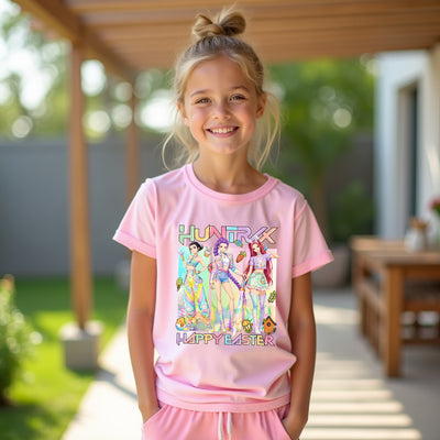 Young girl wearing a pink Kpop 'Happy Easter' t-shirt with cartoon characters outdoors.