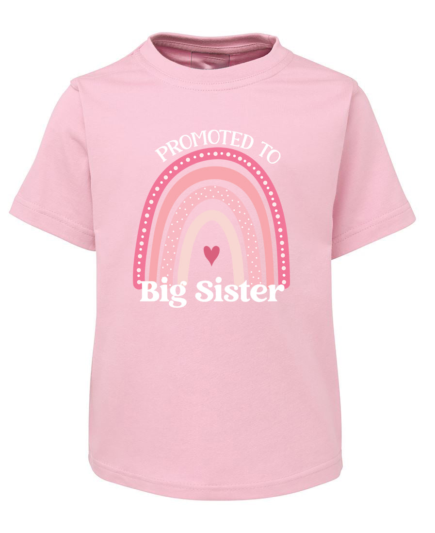 Pink t-shirt with rainbow and heart design, text 'Promoted to Big Sister' on a white background