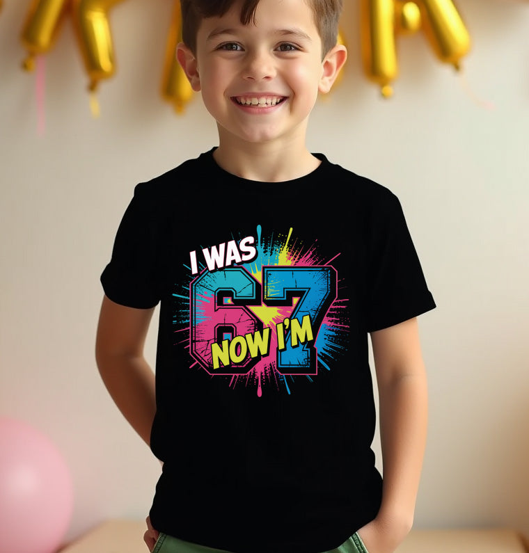 Child wearing a black t-shirt with colorful text 67, standing against a neutral background with balloons.
