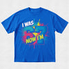 Blue t-shirt with colorful graphic text 'I WAS 67 NOW I'M' on a light gray background
