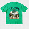 A bright green short-sleeve crewneck t-shirt with a detailed graphic on the front. The graphic features the text 'ADVENTURE Begins WITH A BOOK' in dark green and brown lettering above an illustration of an open book, mountains, pine trees, a river, and a compass.
