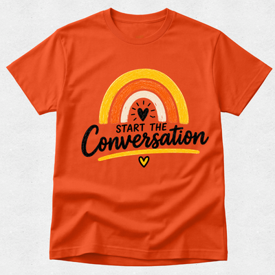 An orange short-sleeve crewneck t-shirt featuring a retro rainbow graphic with the text 'START THE Conversation' in black script and a small yellow heart below, displayed on a light gray textured background.