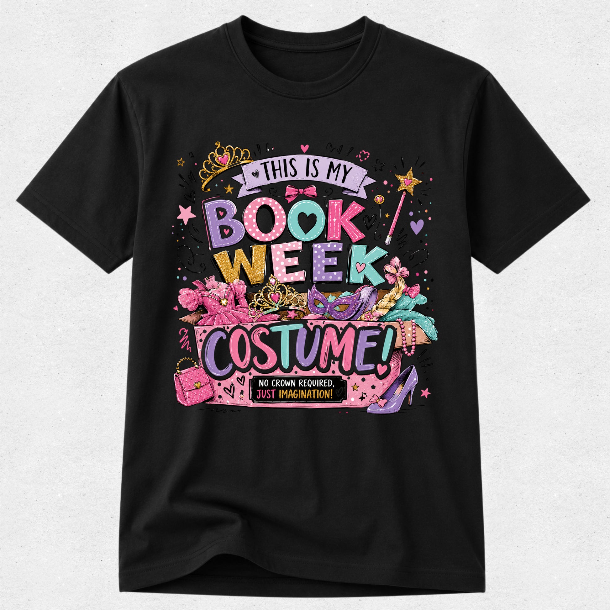 A black short-sleeve crewneck t-shirt featuring a colorful graphic print that reads 'THIS IS MY BOOK WEEK COSTUME!' with illustrations of a pink book, a purple high-heel shoe, a cat-eye sunglasses, and a pink purse on a light gray background.