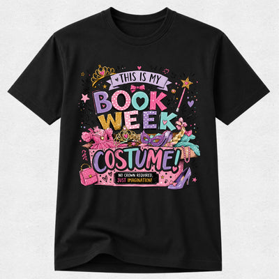 A black short-sleeve crewneck t-shirt featuring a colorful graphic print that reads 'THIS IS MY BOOK WEEK COSTUME!' with illustrations of a pink book, a purple high-heel shoe, a cat-eye sunglasses, and a pink purse on a light gray background.
