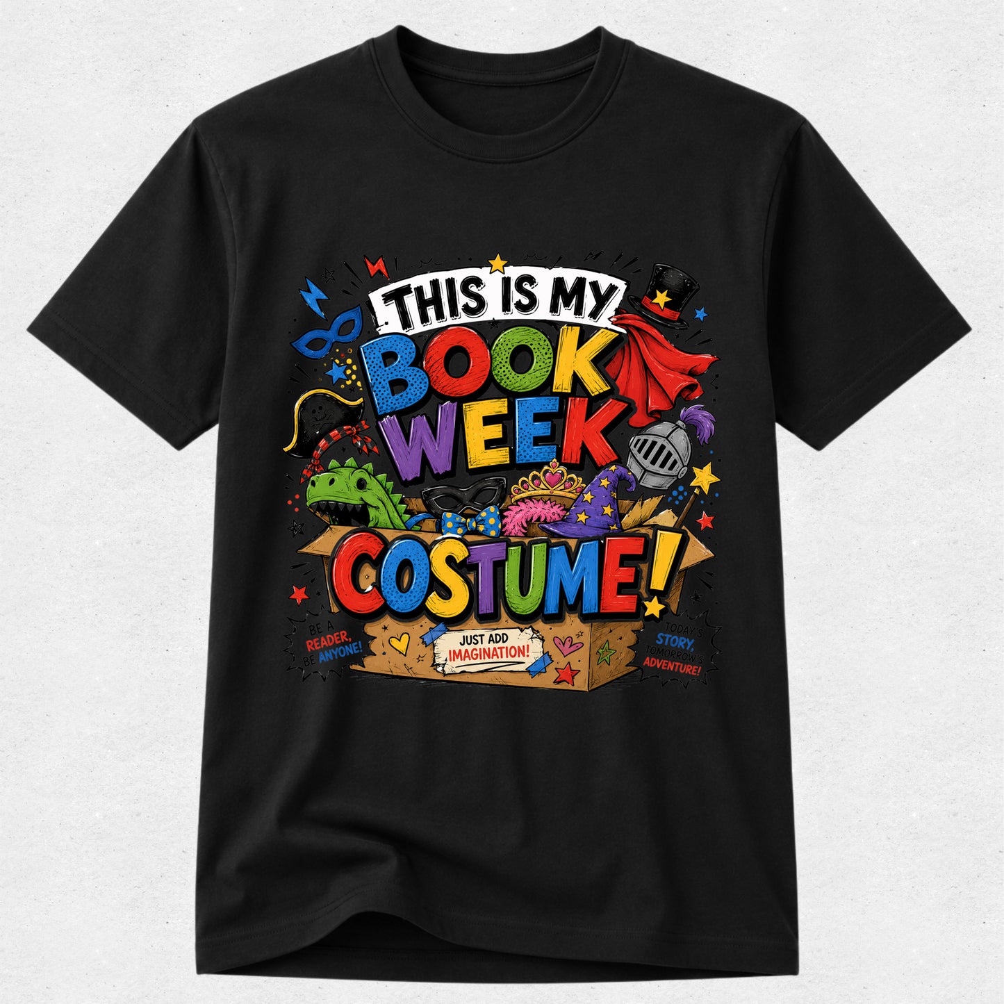 A black short-sleeve crewneck t-shirt featuring a colorful graphic print that reads 'THIS IS MY BOOK WEEK COSTUME!' with cartoon illustrations of a book, superhero cape, dragon, and costume box, shown against a light gray background.