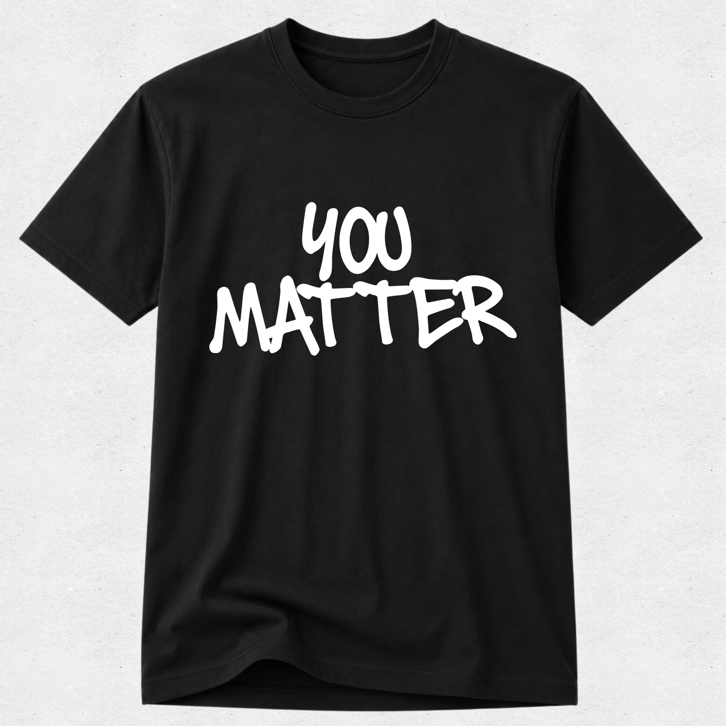 A black short-sleeve crewneck t-shirt with the phrase 'YOU MATTER' printed in a white, hand-drawn brush-style font across the chest, displayed against a light gray textured background.
