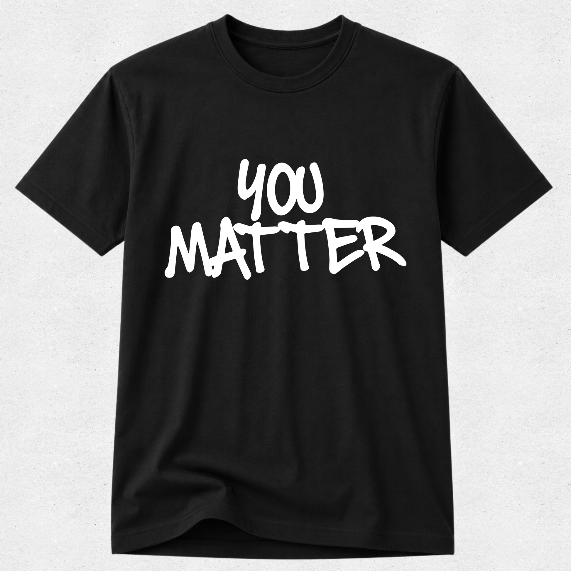 A black short-sleeve crewneck t-shirt with the phrase 'YOU MATTER' printed in a white, hand-drawn brush-style font across the chest, displayed against a light gray textured background.