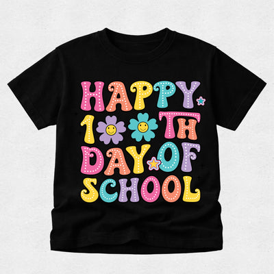 A black short-sleeve kids' t-shirt featuring a colorful graphic that reads 'HAPPY 10TH DAY OF SCHOOL' in playful, multicolored bubble letters with smiley faces and flowers.