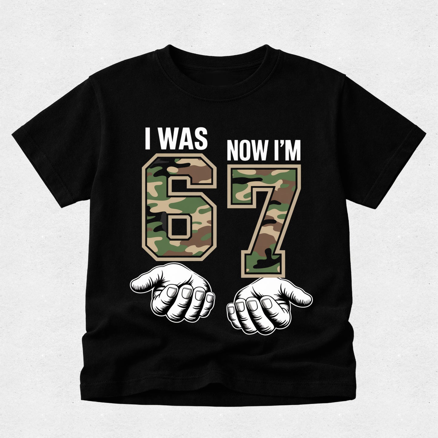 Black t-shirt with camouflage numbers '67' and text 'I was now I'm' on a light gray background