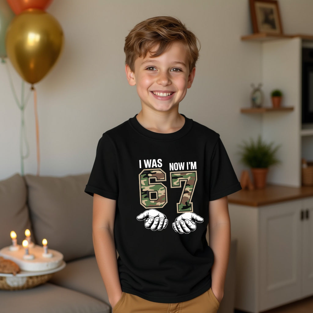 Child wearing a black t-shirt with a camouflage design and text, standing in a living room.