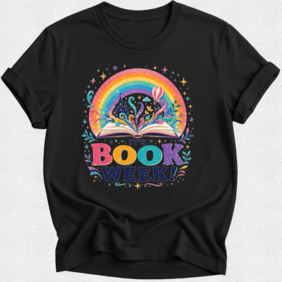 A black short-sleeve crewneck t-shirt featuring a colorful graphic of an open book with a rainbow and stars, and the text 'THE BOOK WEEK!' printed below it.