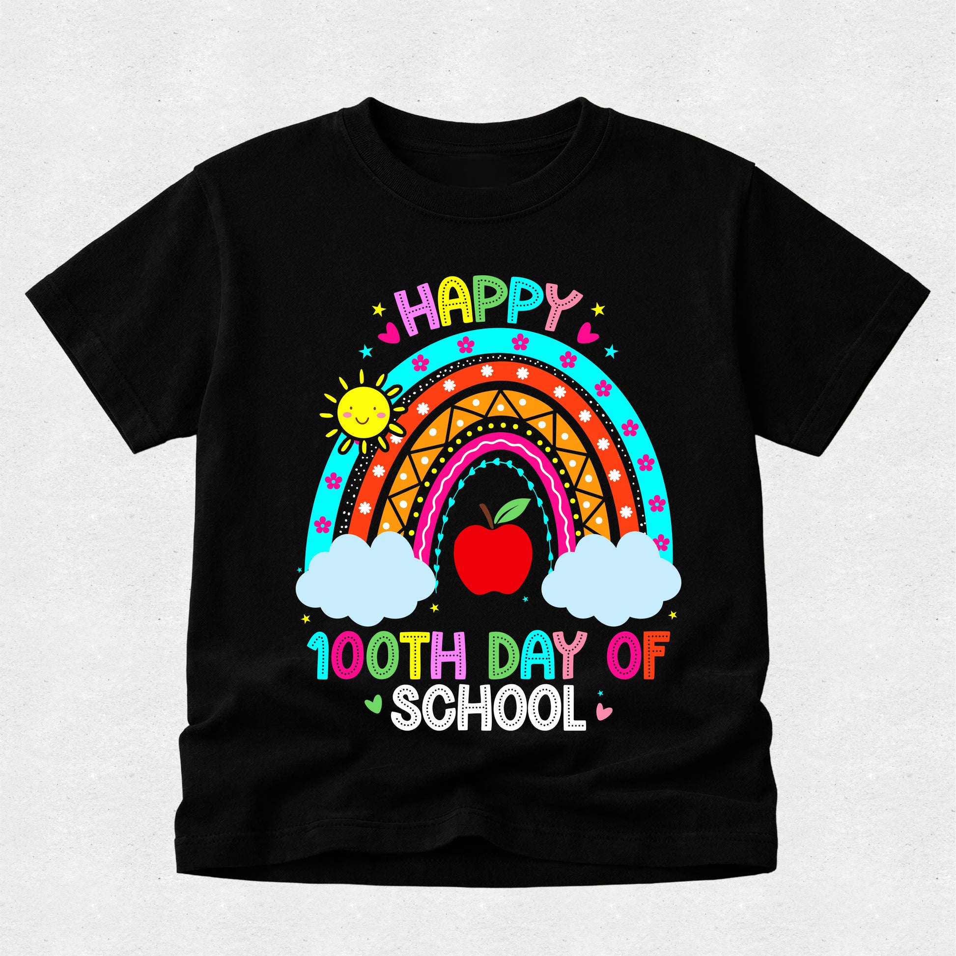 A black short-sleeve t-shirt with a colorful graphic design celebrating '100th Day of School'. The design features a vibrant rainbow, a red apple, two white clouds, a smiling sun, and the text 'HAPPY 100TH DAY OF SCHOOL' in multicolored letters, displayed on a light gray textured background.