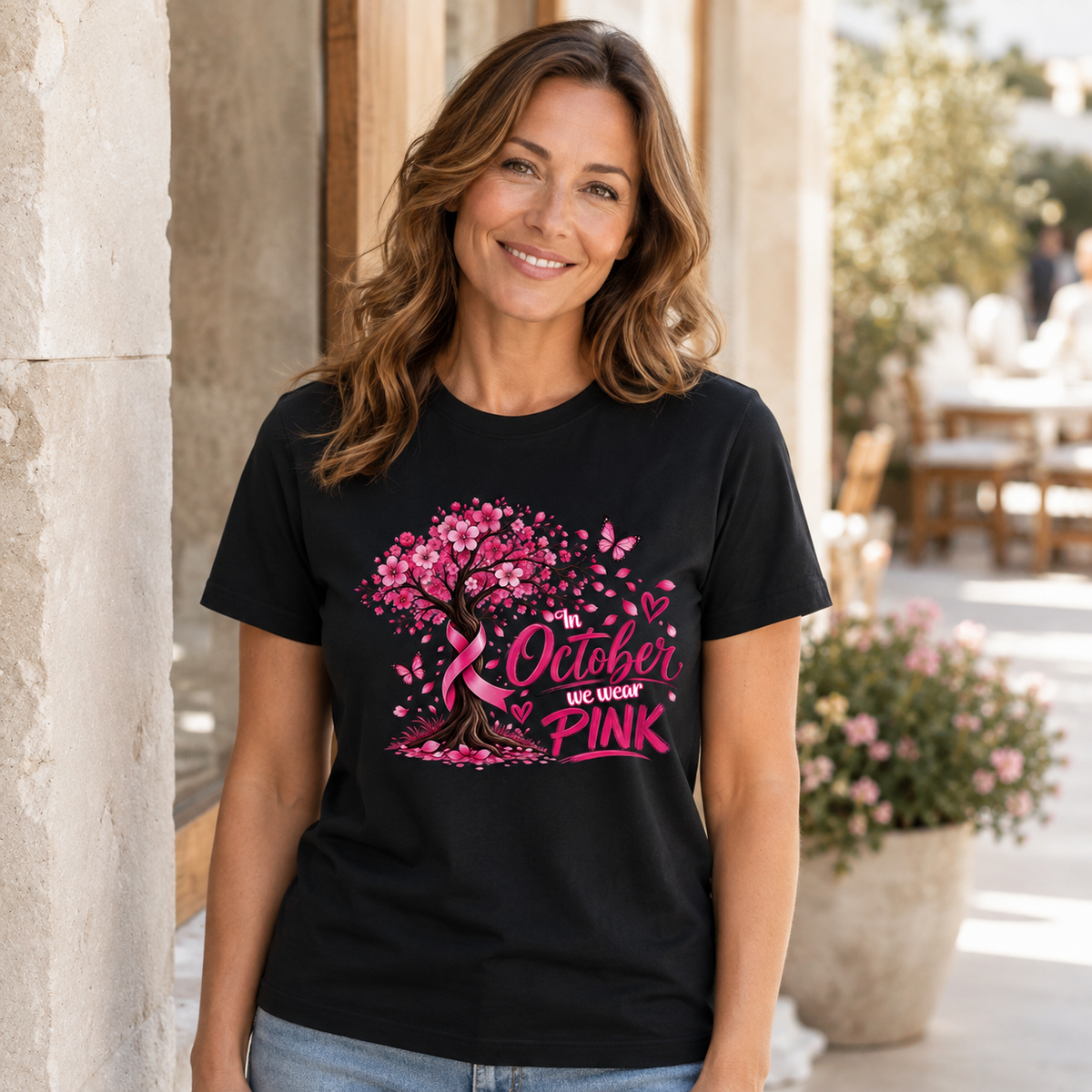 Woman wearing a white breast cancer awareness T-shirt with a heart design made of pink ribbons, flowers and hearts.