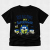A black short-sleeve t-shirt with a colorful graphic on the front that reads 'READING IS MY SUPERPOWER' and 'BOOK WEEK FUEL' around an illustration of a blue monster reading books.