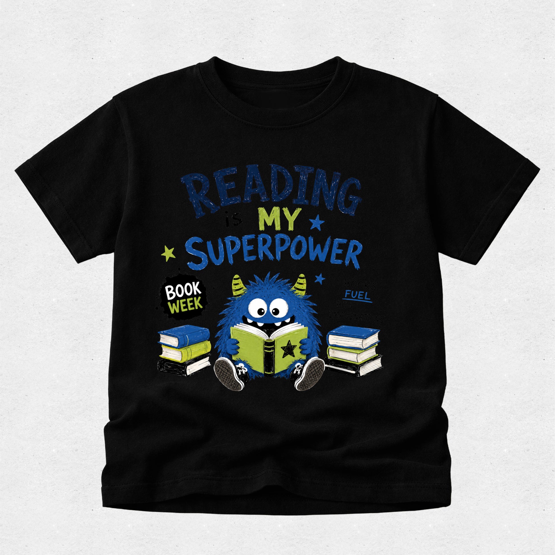 A black short-sleeve t-shirt with a colorful graphic on the front that reads 'READING IS MY SUPERPOWER' and 'BOOK WEEK FUEL' around an illustration of a blue monster reading books.