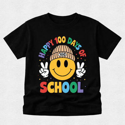 A black short-sleeve t-shirt with a colorful graphic on the front. The graphic features a yellow smiley face wearing a tan beanie with '100' on it, making peace signs with both hands, surrounded by the text 'HAPPY 100 DAYS OF SCHOOL' in rainbow colors.