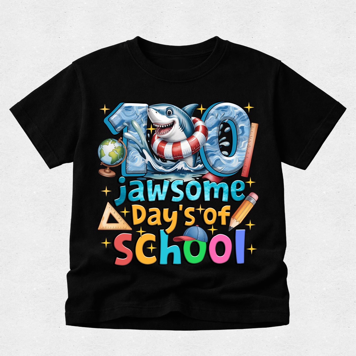 A black short-sleeve t-shirt with a colorful graphic celebrating '100 jawsome Day's of School' featuring a shark in a life preserver and school-themed icons, shown on a light gray background.