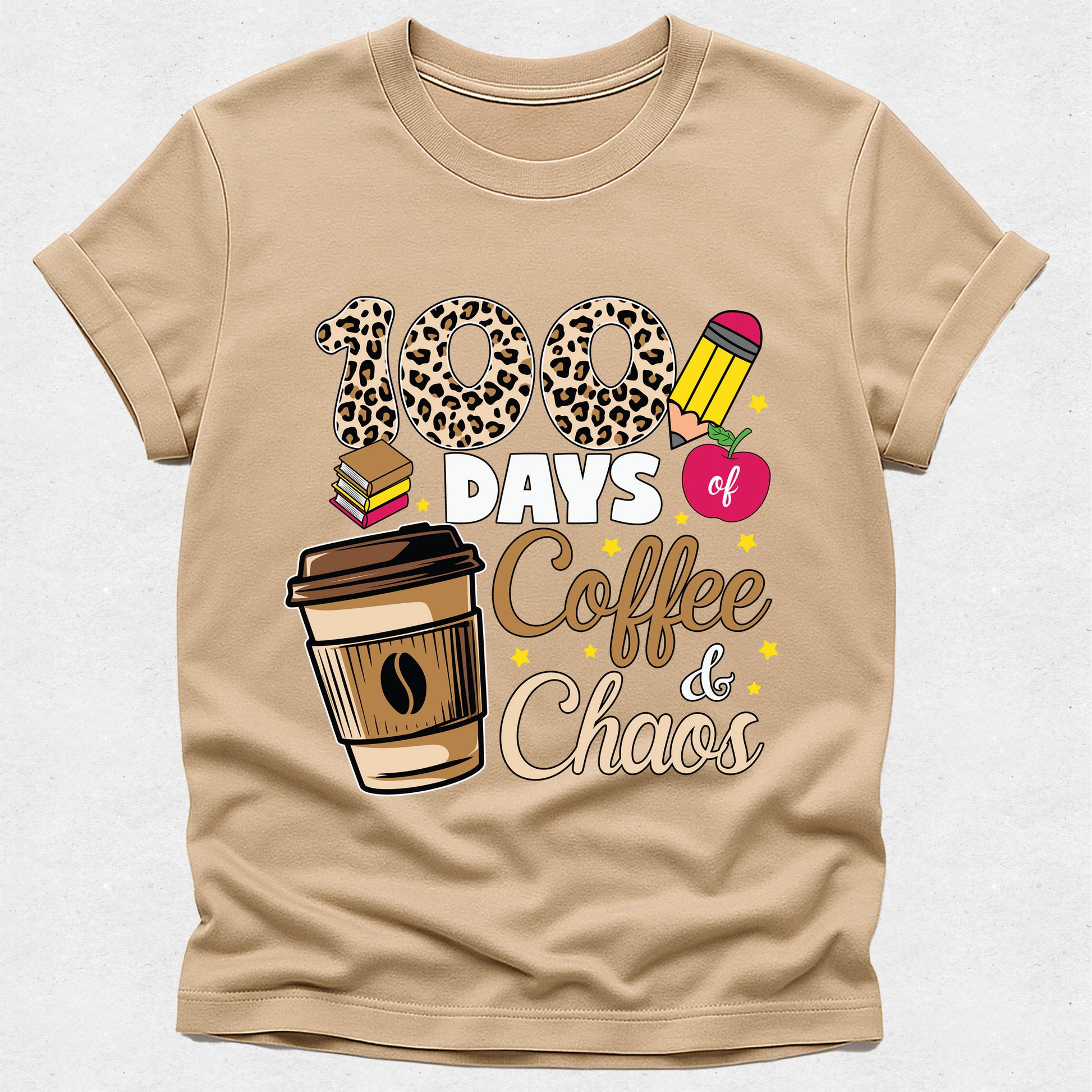 A beige short-sleeve t-shirt with a graphic print that reads '100 DAYS of Coffee & Chaos' in a mix of leopard print, white, brown, and pink fonts, accompanied by illustrations of a coffee cup, books, and a pencil.