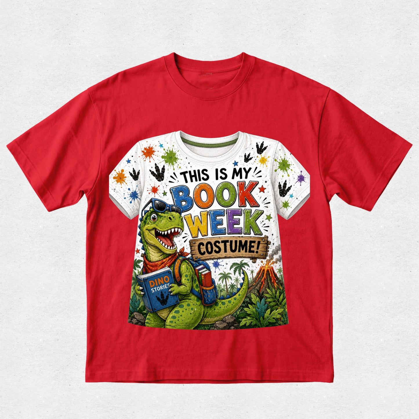 A red short-sleeve crewneck t-shirt featuring a colorful graphic print on the front. The graphic shows a green cartoon dinosaur wearing blue glasses and a red bandana, holding a book, with the text 'THIS IS MY BOOK WEEK COSTUME!' in multicolored letters.