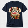 A navy blue short-sleeve crewneck t-shirt featuring a detailed graphic print of a pirate costume with the text 'THIS BE MY BOOK WEEK COSTUME!'. The graphic includes a white tattered shirt, red bandana, gold pirate belt, and treasure elements, displayed on a light gray background.