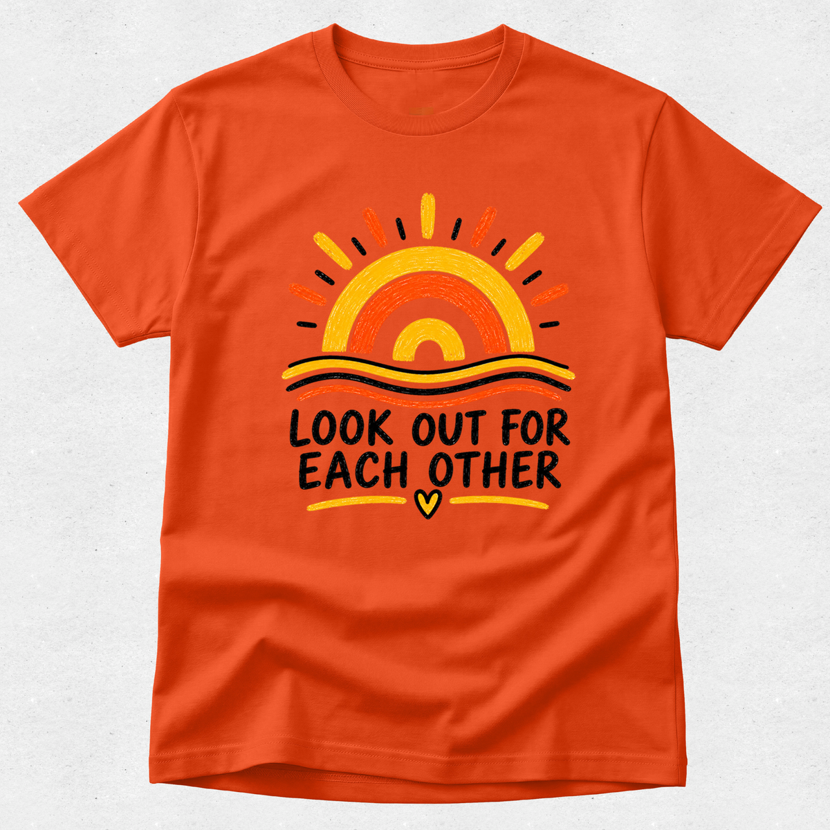 An orange crewneck t-shirt featuring a retro sunset graphic and the text 'LOOK OUT FOR EACH OTHER' in black, with a small yellow heart at the bottom.