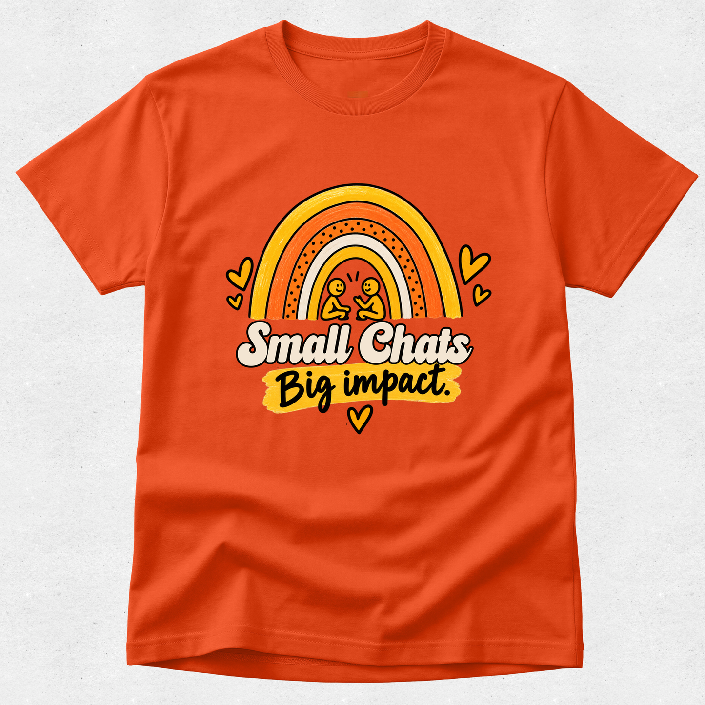 An orange crewneck t-shirt featuring a retro-style rainbow graphic with two small stick-figure-like characters and the text 'Small Chats Big impact.' in white and yellow, displayed on a light gray textured background.