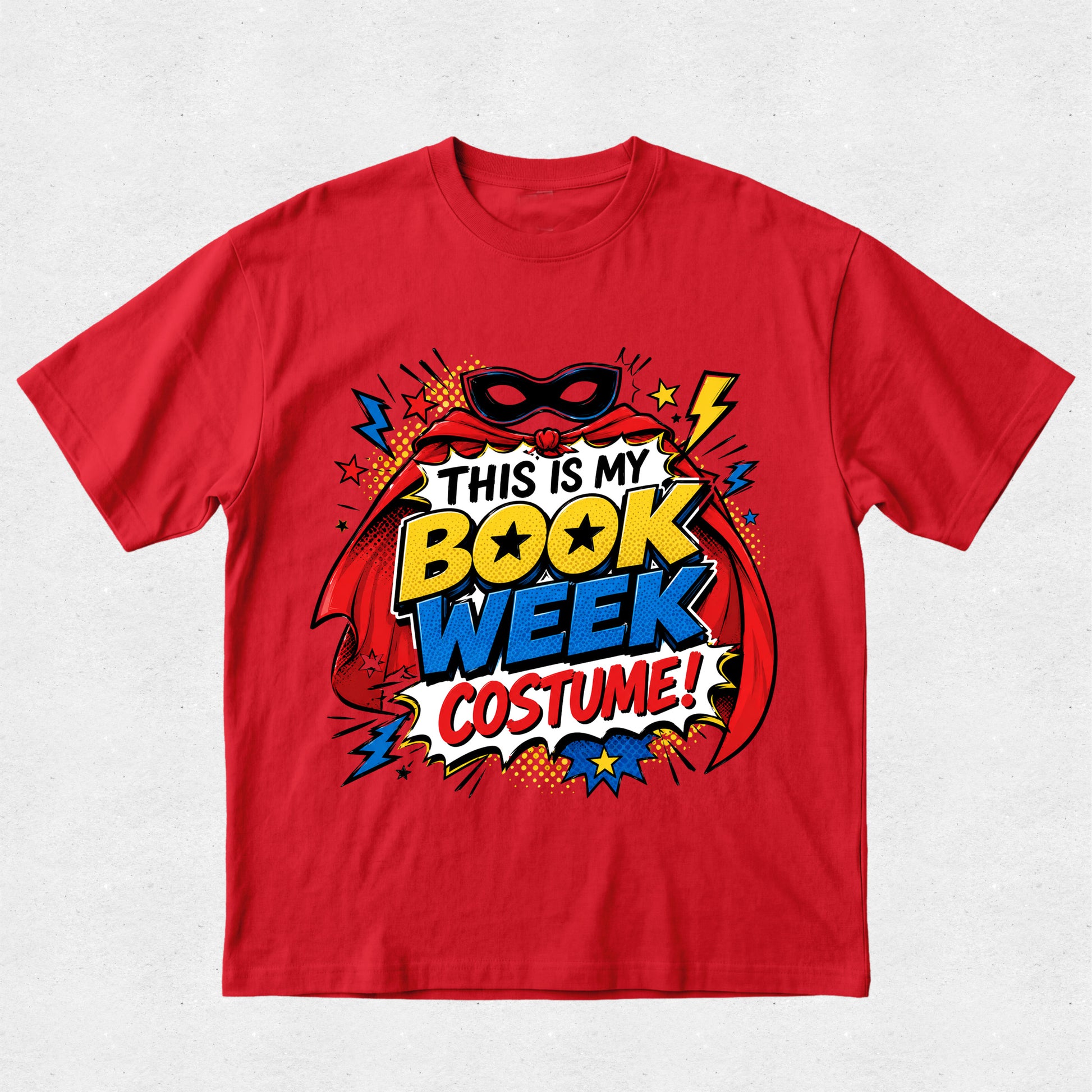 A red short-sleeve crewneck t-shirt featuring a colorful comic book style graphic that reads 'THIS IS MY BOOK WEEK COSTUME!' with a superhero mask, cape, and comic-style text elements.