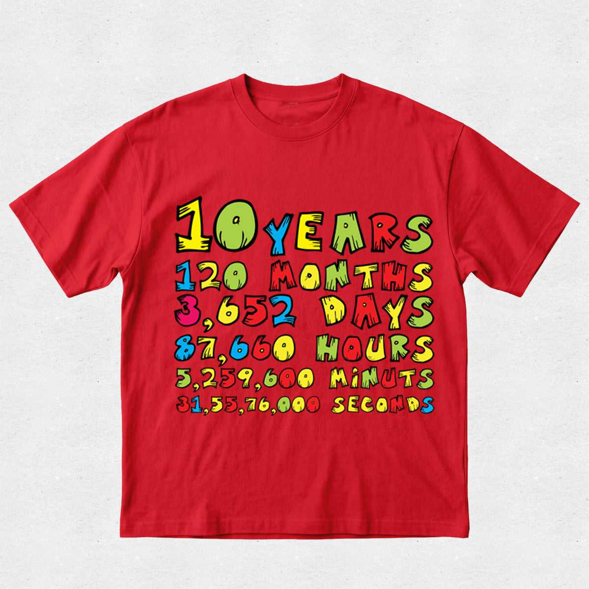 A red short-sleeve crewneck t-shirt featuring a colorful retro graphic on the front that lists time conversions: 10 Years, 120 Months, 3,652 Days, 87,660 Hours, 3,259,000 Minutes, and 51,532,000 Seconds.