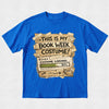 A bright blue short-sleeve t-shirt with a graphic print on the front. The graphic features a rustic, torn-paper design in beige and brown tones with the text 'THIS IS MY BOOK WEEK COSTUME!' and a 'COSTUME LOADING.