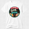 A white short-sleeve crewneck t-shirt featuring a colorful circular graphic on the chest that reads 'IT'S BOOK WEEK' with stylized books and stars.