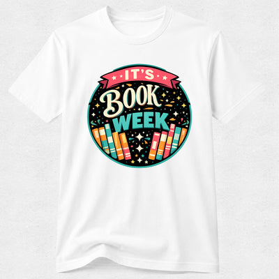A white short-sleeve crewneck t-shirt featuring a colorful circular graphic on the chest that reads 'IT'S BOOK WEEK' with stylized books and stars.