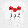White t-shirt with red poppies and 'Lest We Forget' text on a white background