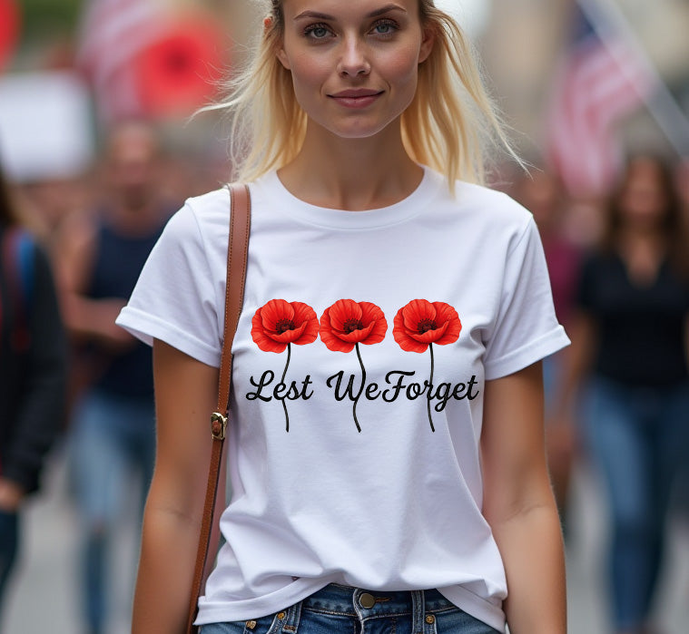 Woman wearing a white t-shirt with red poppies and 'Lest We Forget' text in a crowd.