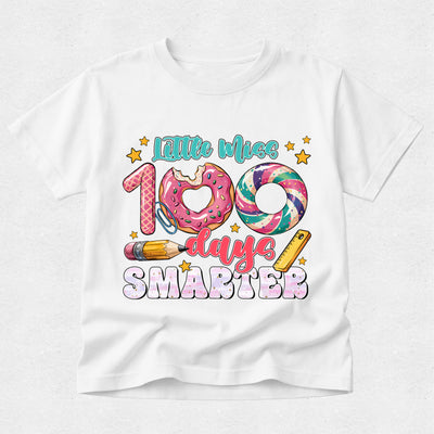 A white short-sleeve t-shirt with a colorful graphic on the front that reads 'Little Miss 109 days SMARTER' with a donut, swirl donut, pencil, and star details, shown on a light gray background.