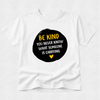 A white short-sleeve crewneck t-shirt with a black circular graphic on the chest containing the text 'BE KIND YOU NEVER KNOW WHAT SOMEONE IS CARRYING' in yellow and white, with a small yellow heart below.
