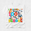 A white short-sleeve crewneck t-shirt featuring a colorful graphic print on the front that reads 'I BLASTED through 100 days of SCHOOL' with cartoon illustrations of a sun, astronaut, rocket ship, and planets.