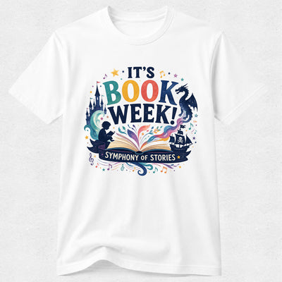 A white short-sleeve crewneck t-shirt featuring a colorful graphic print that reads 'IT'S BOOK WEEK! Symphony of Stories' with illustrations of a castle, dragon, open book, and pirate ship.