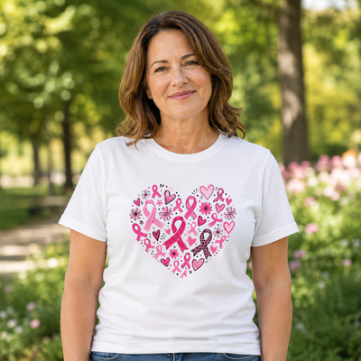 Woman wearing a white breast cancer awareness T-shirt with a heart design made of pink ribbons, flowers and hearts.