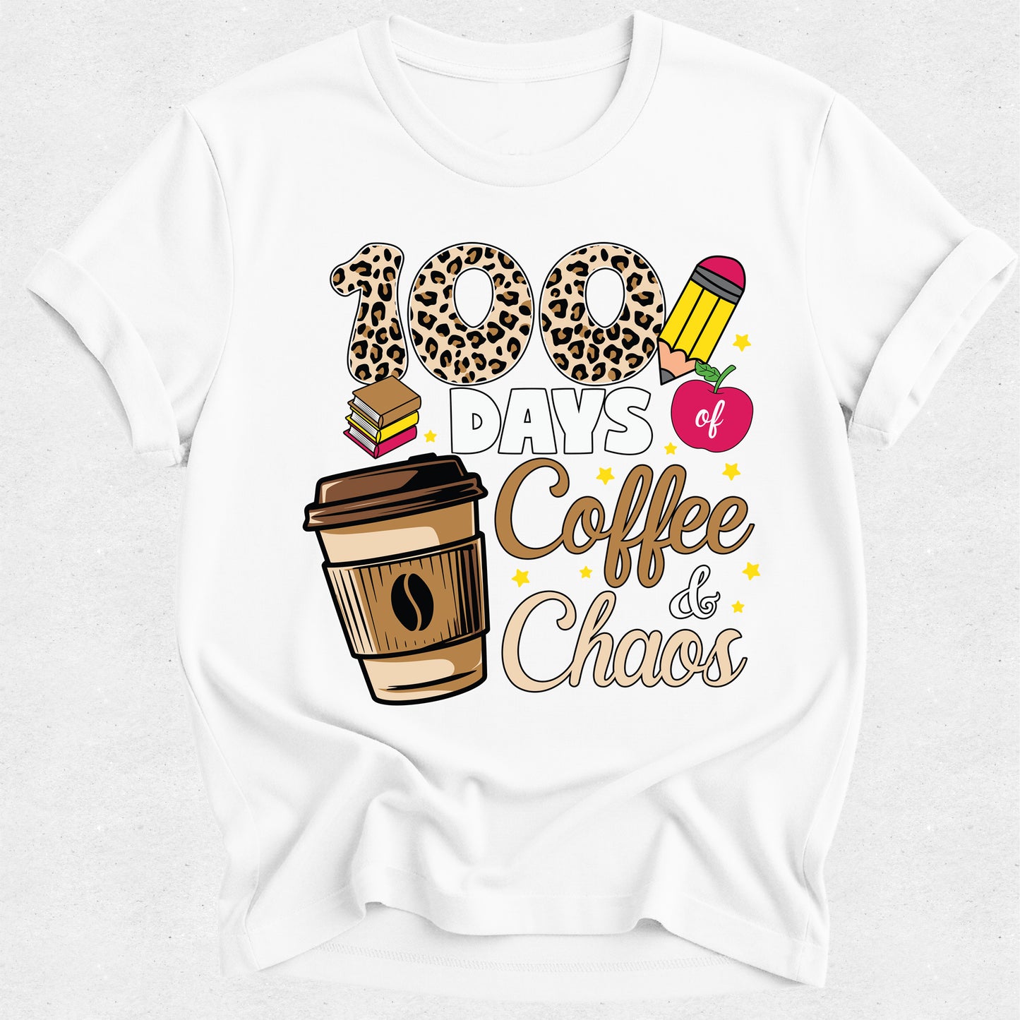 A white short-sleeve crewneck t-shirt featuring a graphic design that reads '100 DAYS of Coffee & Chaos' in leopard print, brown, pink, and gold tones, accompanied by illustrations of a coffee cup, books, and an apple.