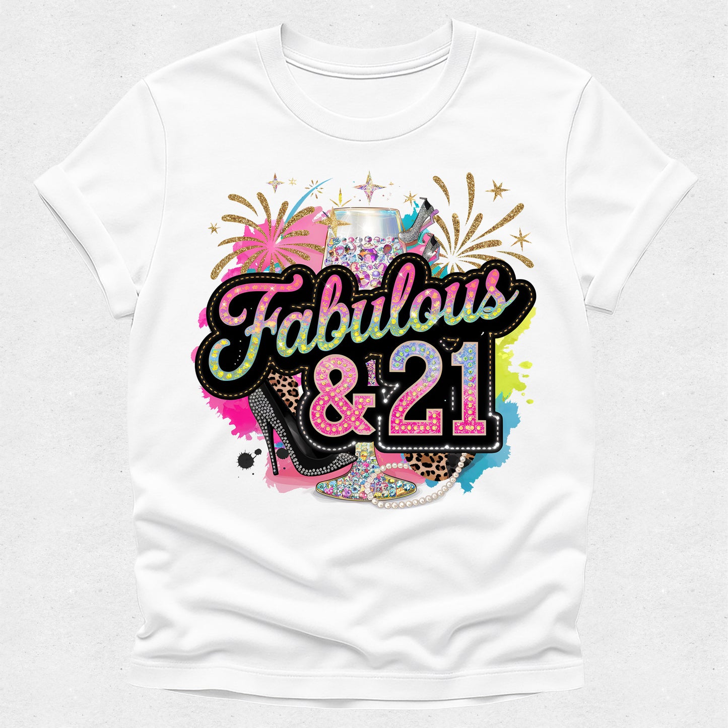 White t-shirt with colorful 'Fabulous & 21' design featuring a high heel, tiara, and fireworks on a white background.